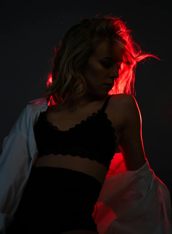 a woman standing in front of a red light, dramatic product lighting, revealing clothes, profile image, exposed midriff