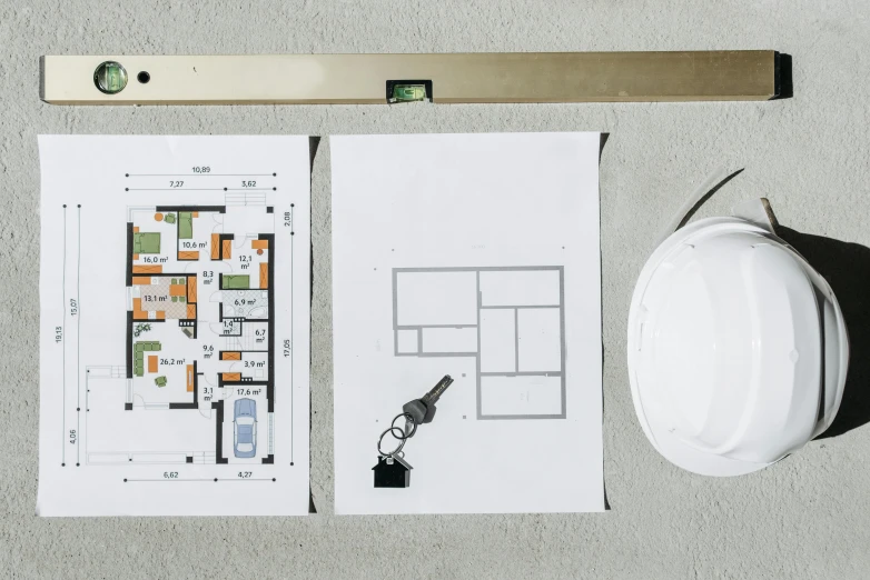 a white hard hat sitting on top of a table, a cartoon, unsplash, floor plan, posters on the walls, high angle close up shot, architectural digest photo