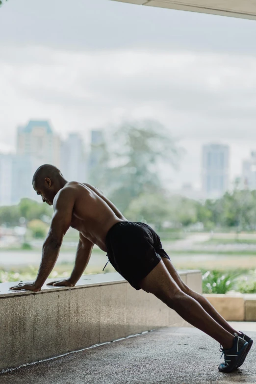 a man doing push ups on a concrete ledge, by Julian Allen, happening, malaysian, natural light outside, profile image, lush surroundings