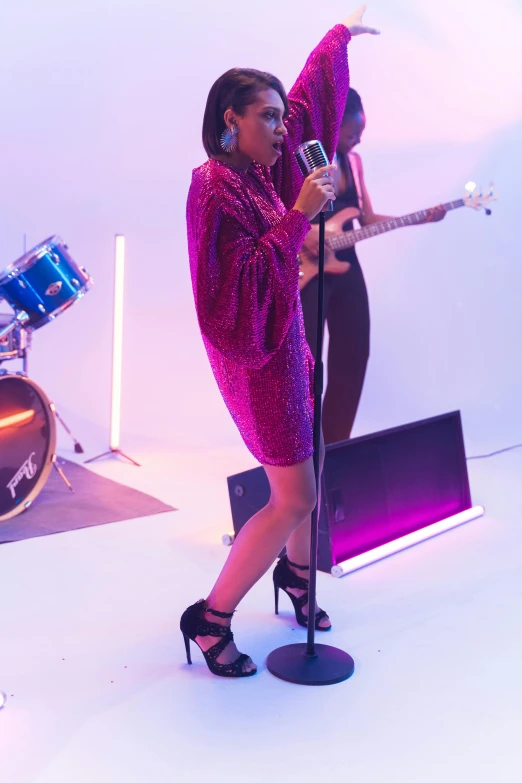 a woman in a red dress singing into a microphone, trending on pexels, happening, purple scene lighting, sleek legs, still from a music video, at a fashion shoot