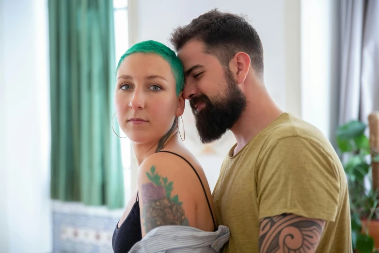 a man and a woman standing next to each other, a tattoo, by Jessie Alexandra Dick, pexels contest winner, short unkempt green hair, couple on bed, 2 5 yo, partially bald