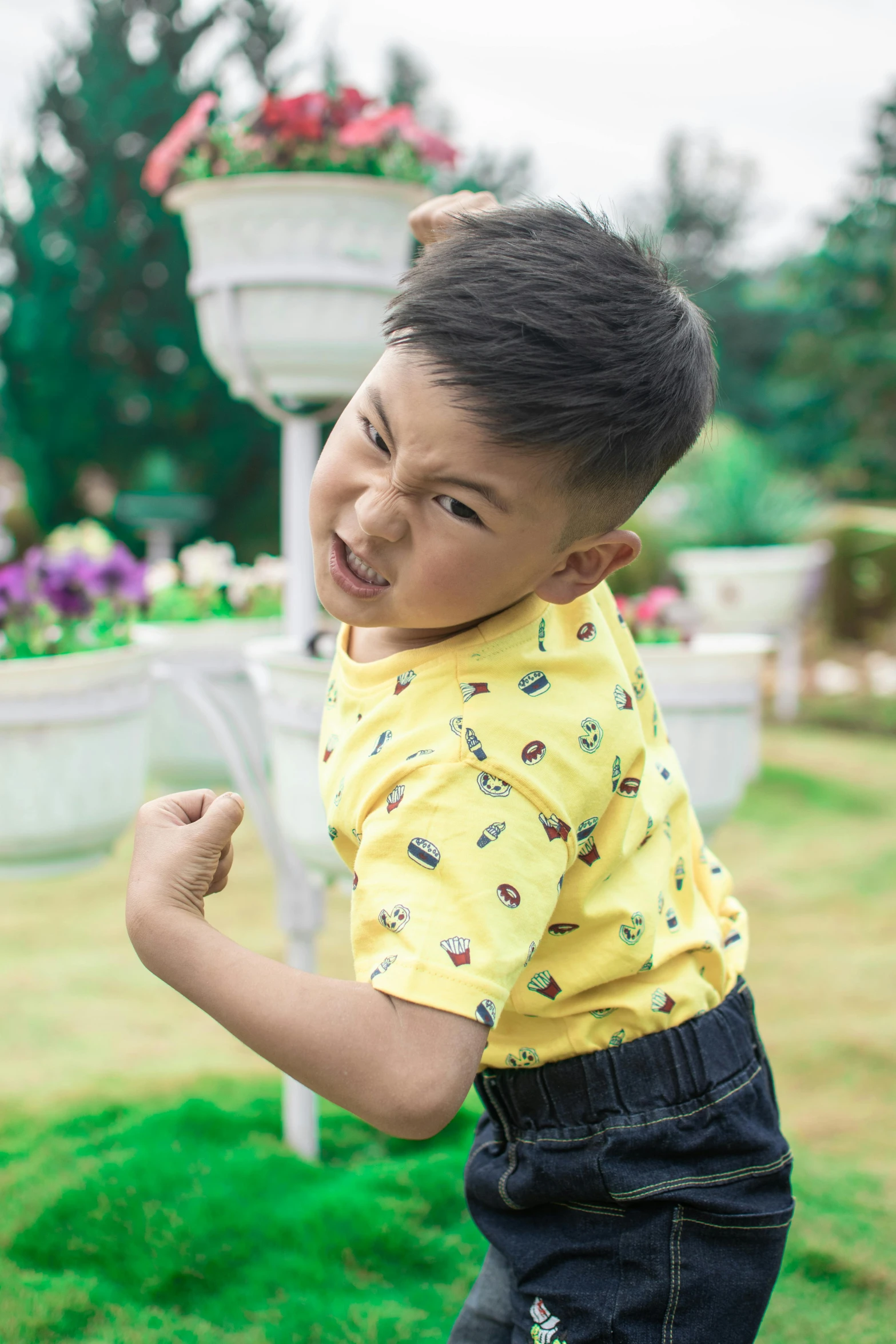 a little boy that is standing in the grass, inspired by Abidin Dino, pexels contest winner, happening, wearing yellow floral blouse, showing off biceps, asian male, fighting stance