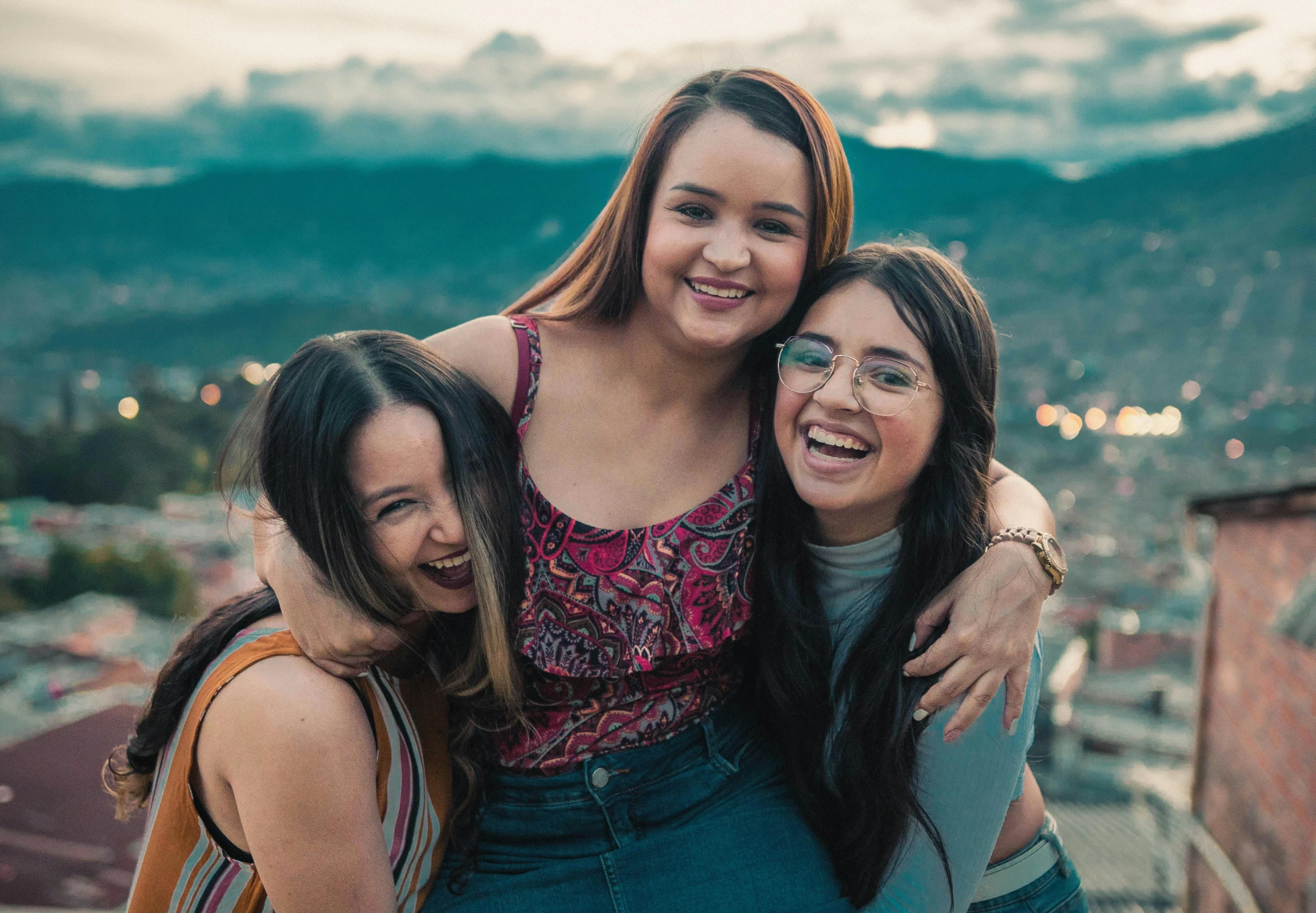 a group of three women standing next to each other, by Amelia Peláez, trending on pexels, happening, happy girl, high angle close up shot, teenage girl, hills in the background