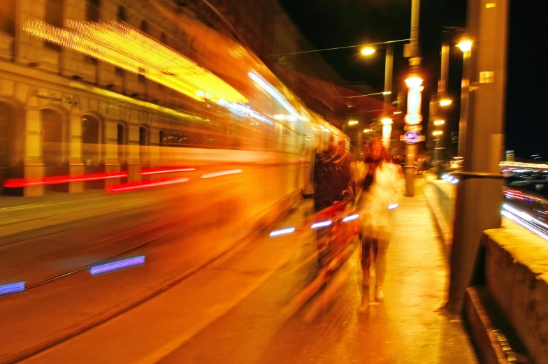 a blurry photo of a city street at night, by Mirko Rački, pexels contest winner, happening, public bus, orange line, people running away, taken in the late 2010s