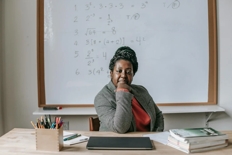 a woman sitting at a desk in front of a whiteboard, paris school, jemal shabazz, taken in 2 0 2 0, algebra, portrait photo