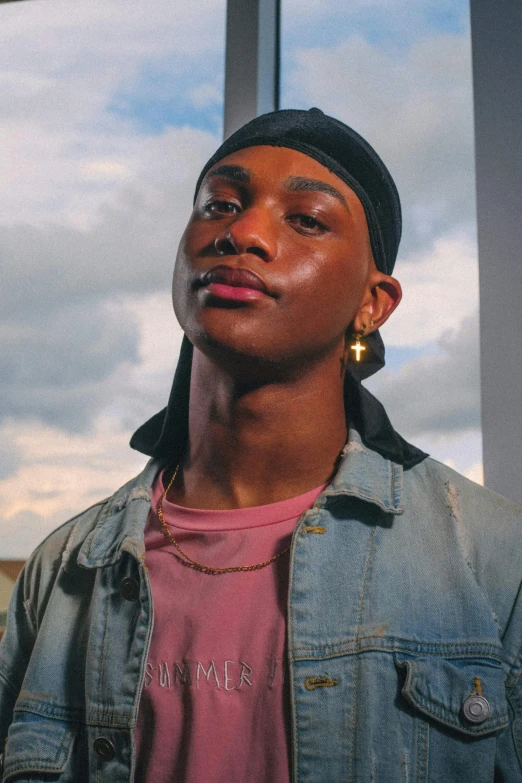 a young man standing in front of a window, by Cosmo Alexander, trending on pexels, wearing a chocker and cute hat, patron saint of 🛸🌈👩🏾, huge earrings and queer make up, 90's photo