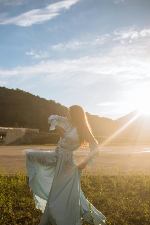 a woman standing on top of a lush green field, inspired by Oleg Oprisco, unsplash, renaissance, sun flare, doing a sassy pose, grey, golden hour 8k