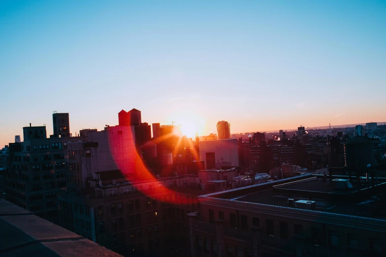 the sun is setting over a city skyline, a picture, happening, unsplash photography, fan favorite, shot from roofline, new york backdrop