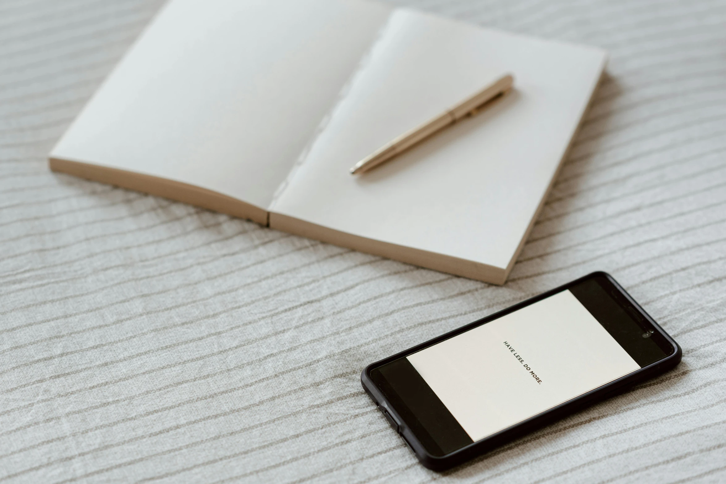 a cell phone sitting on top of a bed next to an open book, trending on pexels, postminimalism, pen on white paper, intricate writing, no - text no - logo, thumbnail