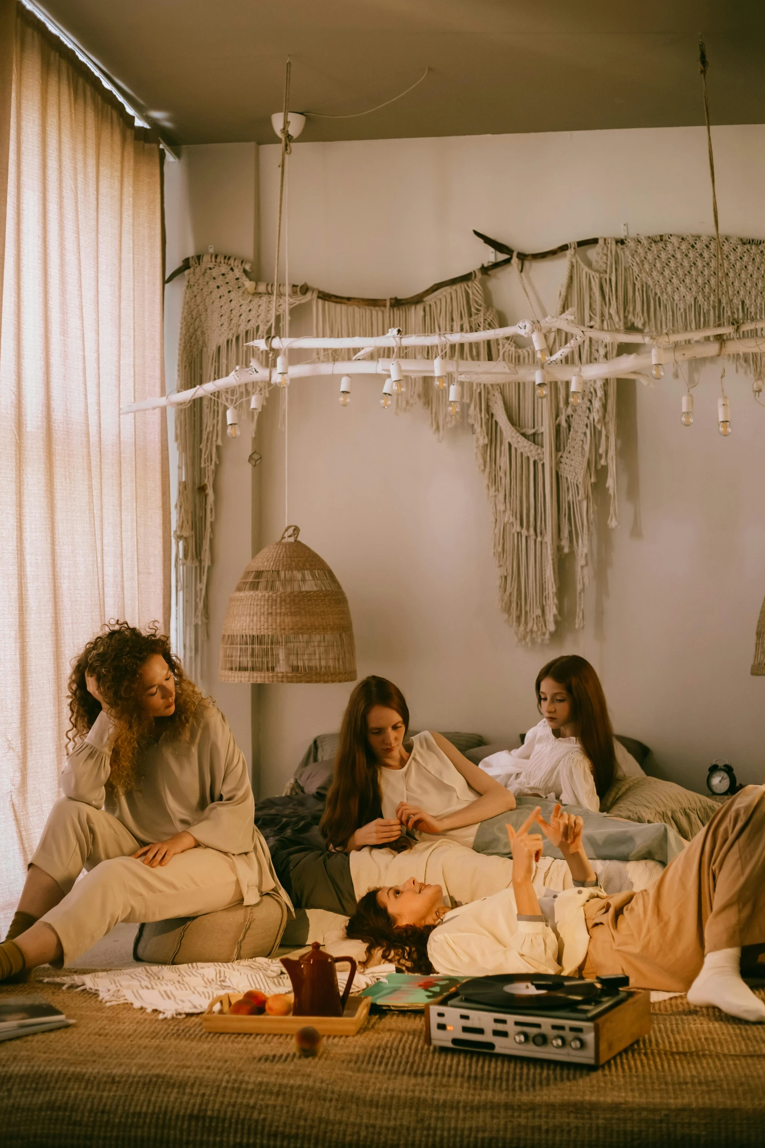 a group of people sitting on top of a bed, by Elsa Bleda, trending on pexels, renaissance, in a white boho style studio, girls resting, calmly conversing 8k, lounge room