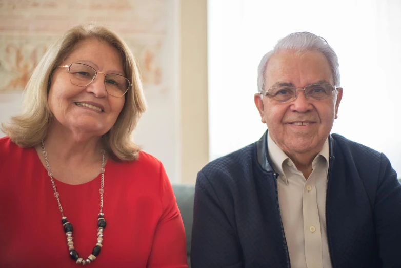 a man and a woman sitting next to each other, a portrait, eloy morales, background image, two old people, professional photo