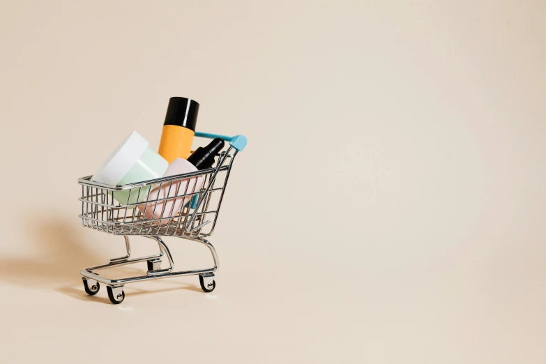 a small shopping cart filled with personal care products, by Emma Andijewska, on a pale background, fan favorite, ground - level medium shot, burberry