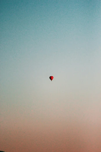 a hot air balloon is flying in the sky, an album cover, unsplash contest winner, postminimalism, photo taken on fujifilm superia, red, early morning, floating alone