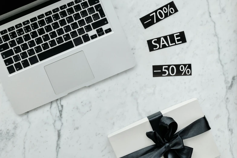 a laptop computer sitting on top of a marble table, by Emma Andijewska, trending on unsplash, renaissance, retail price 4 5 0, festive, bows, white and black clothing