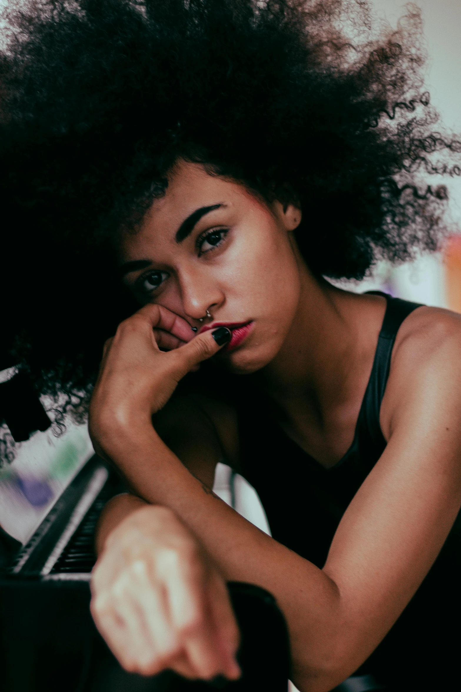 a woman sitting in front of a piano, pexels contest winner, antipodeans, with afro, pouty, strong woman, photo of young woman