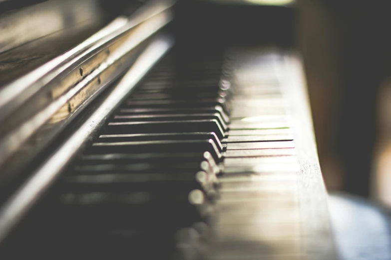 a close up of the keys of a piano, an album cover, pexels, muted lights, instagram photo, small depth of field, faded worn