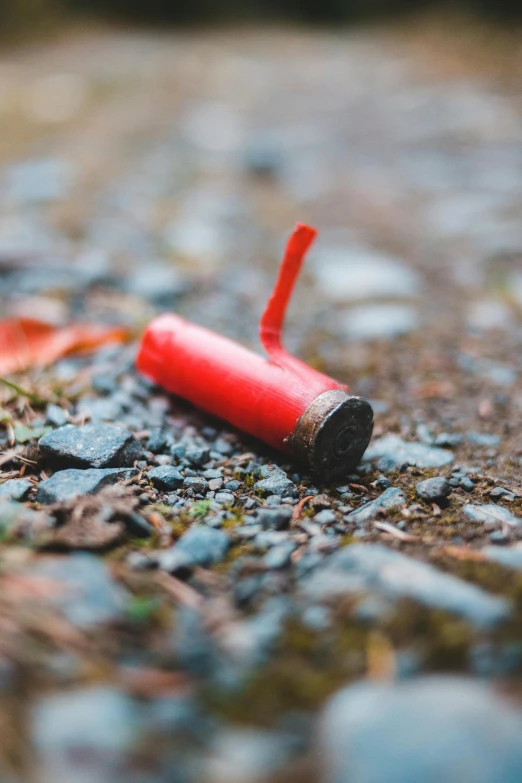 a close up of a red object on the ground, a picture, unsplash, auto-destructive art, shotgun, chalk, litter, ( ( ( ( ( bomb
