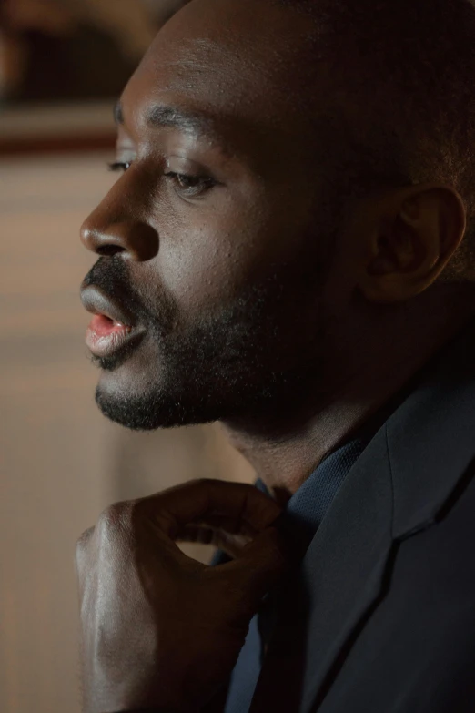 a close up of a person wearing a suit and tie, inspired by David Bailly, happening, contemplative, man is with black skin, worship, film still