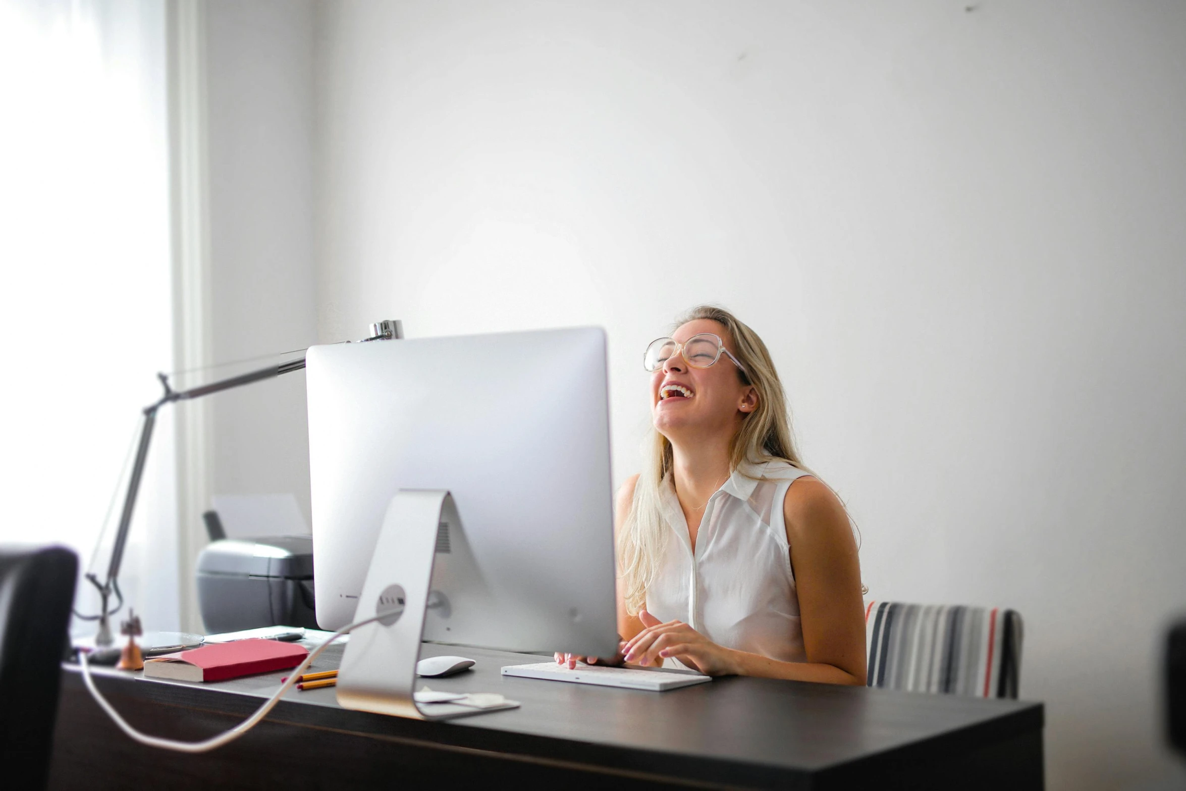 a woman sitting at a desk in front of a computer, pexels contest winner, head bent back in laughter, ui and ux, female in office dress, female gigachad