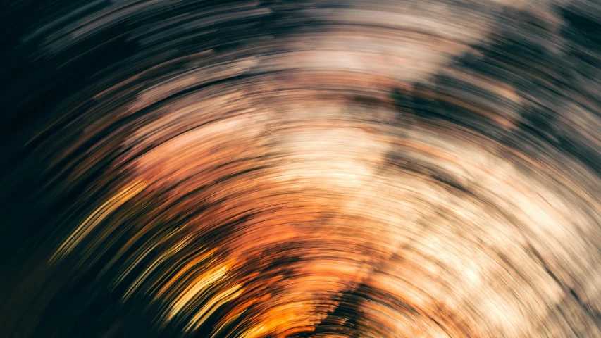 a blurry image of a light at the end of a tunnel, an album cover, by Carey Morris, trending on unsplash, abstract illusionism, gold striated swirling finish, spinning whirlwind, orange gradient, evening lights