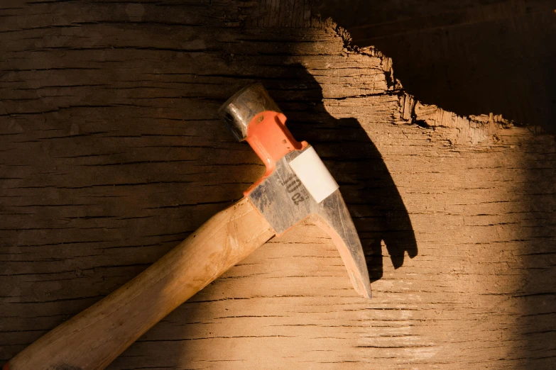 a hammer sitting on top of a piece of wood, pexels contest winner, figuration libre, background image, afternoon lighting, brown, craggy