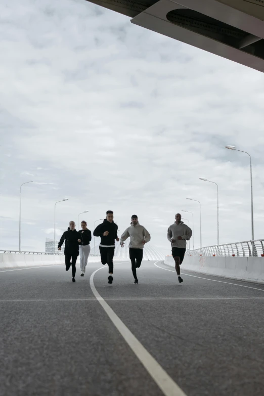 a group of people running across a bridge, by Christen Dalsgaard, happening, jovana rikalo, low quality photo, sweat, hammershøi