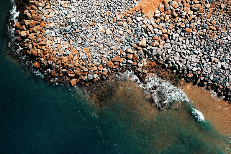 a bird's eye view of a rocky beach, unsplash contest winner, burnt sienna and cerulean blue, manly, ((rocks)), bird\'s eye view