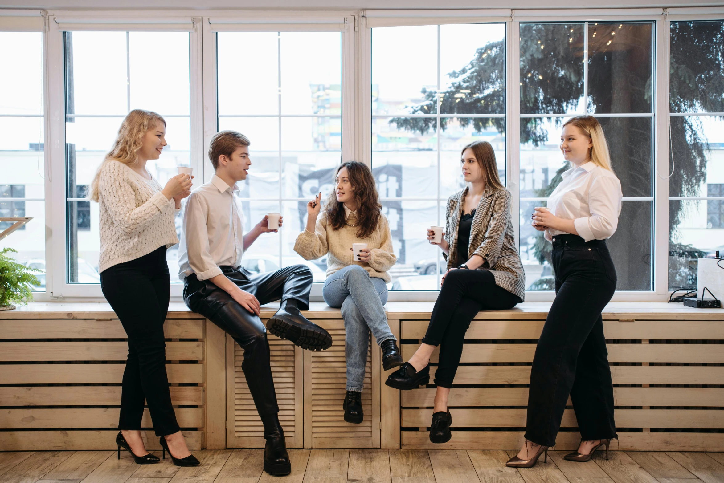 a group of women sitting on top of a window sill, trending on pexels, aussie baristas, on a white table, sitting in a waiting room, flirting