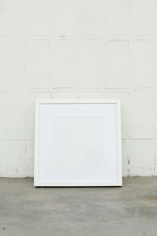 a picture frame leaning against a white brick wall, a picture, unsplash, visual art, square, soft white rubber, white french bob, in front of white back drop