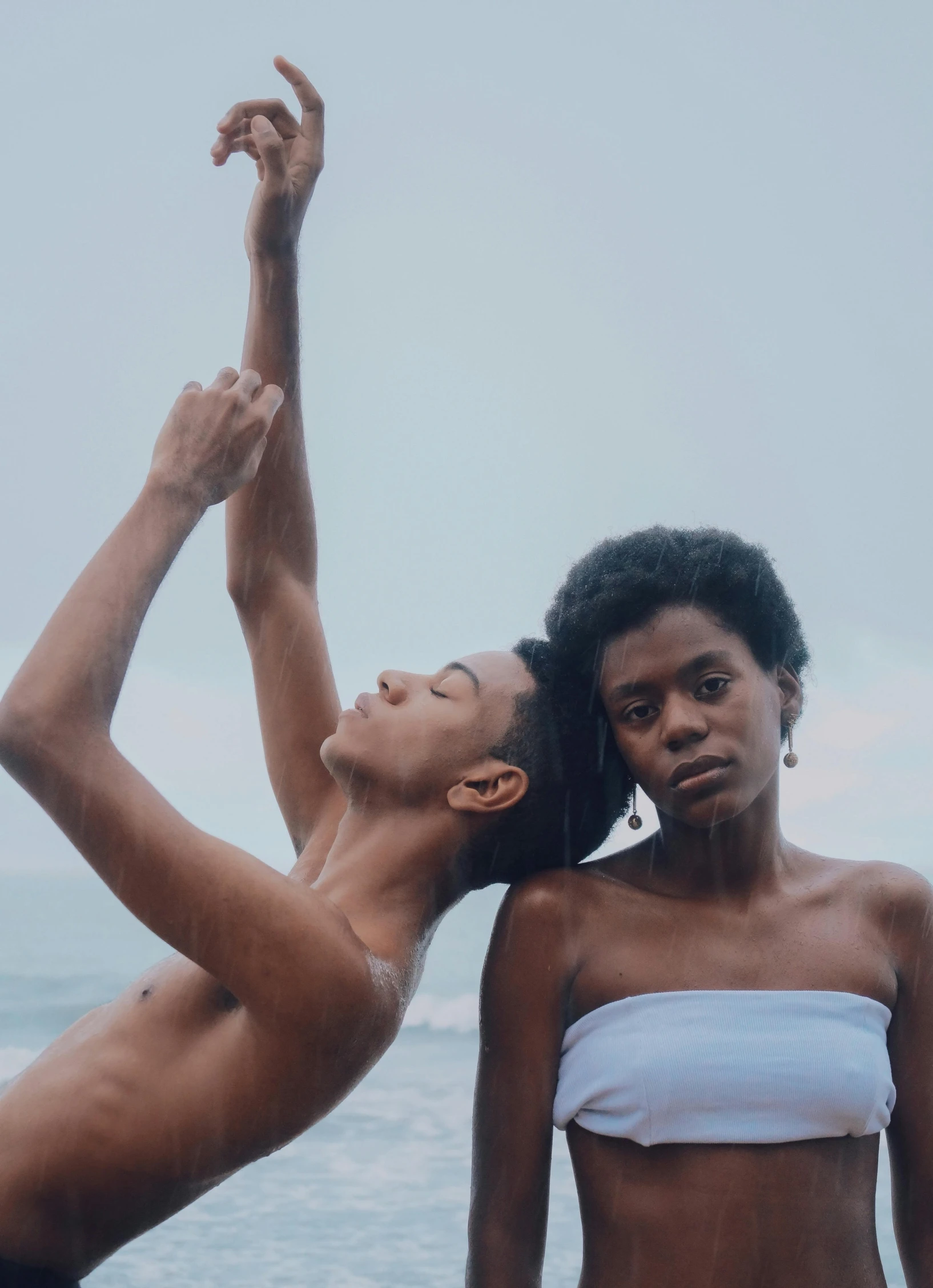 a couple of women standing next to each other on a beach, pexels contest winner, black arts movement, dancers, androgynous person, hands reaching for her, brazil