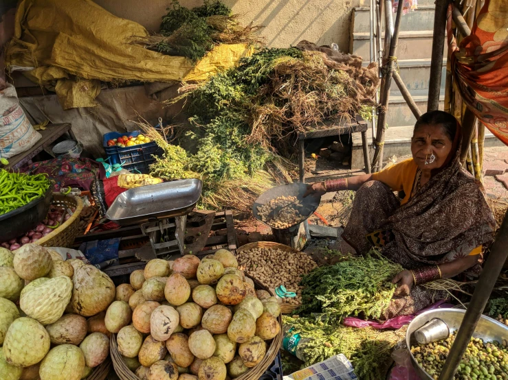 a woman sitting in front of a pile of vegetables, unsplash, on an indian street, square, avatar image, thumbnail