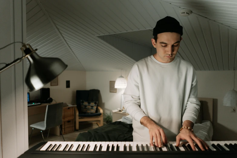 a man that is standing in front of a keyboard, by Carey Morris, pexels contest winner, hyperrealism, performing a music video, cozy environment, lachlan bailey, slight overcast lighting