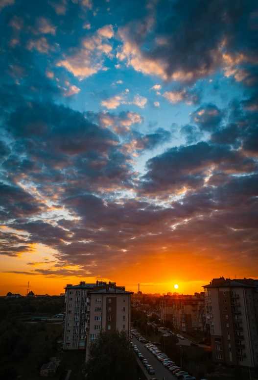 the sun is setting over a city with tall buildings, by Sven Erixson, unsplash contest winner, rostov, today\'s featured photograph 4k, square, sunset and big clouds behind her