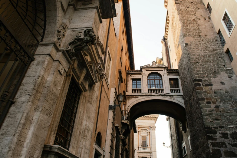 a narrow alley with a clock tower in the background, pexels contest winner, neoclassicism, lots of roman arches, looking from slightly below, afternoon light, raising between the buildings