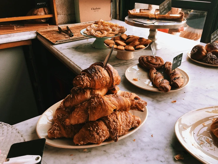 a counter topped with lots of different types of pastries, unsplash, happening, perfect crisp sunlight, 🦩🪐🐞👩🏻🦳, grain”, edouard caplain