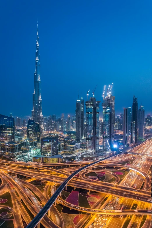 an aerial view of a city at night, pexels contest winner, hurufiyya, sheikh mohammed ruler of dubai, tall buildings in background, 8k resolution”, majestic spires