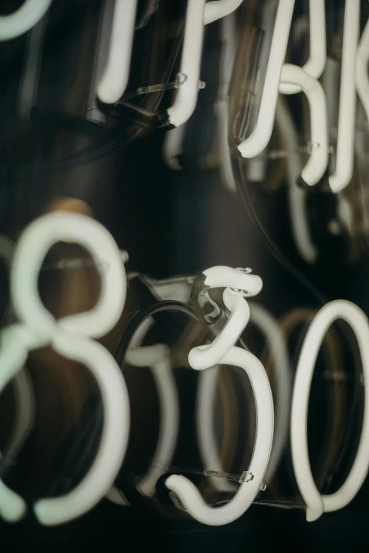 a close up of a sign in a store window, inspired by Bruce Munro, trending on unsplash, kinetic art, bicycles, numerical, lighting 8k, white mechanical details