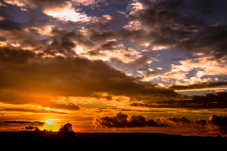 the sun is setting behind the clouds in the sky, by Jesper Knudsen, pexels contest winner, romanticism, panorama, big island, brown, dramatic ”
