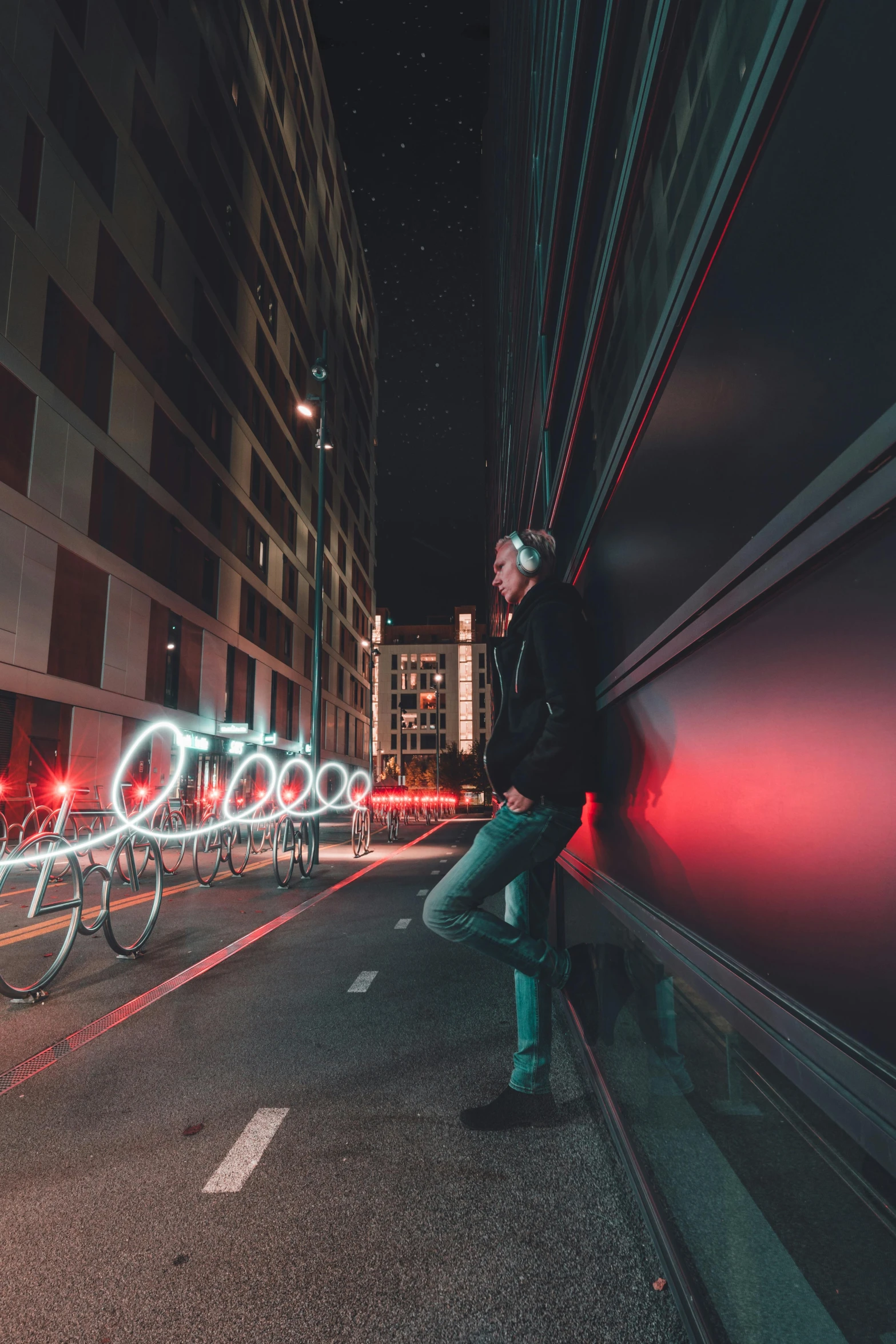 a man standing in the middle of a city street, unsplash contest winner, cyber neon lightings, leaning on the wall, music, wide view