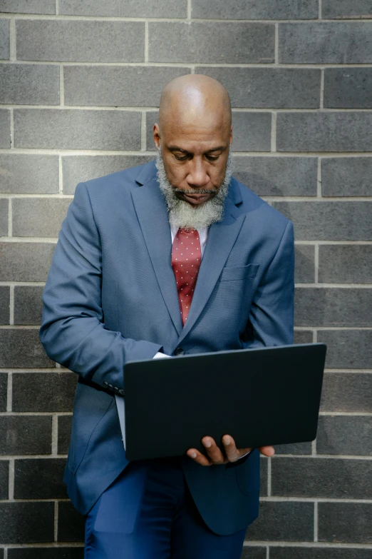 a man in a suit and tie holding a laptop, inspired by James E. Brewton, grey beard, 2019 trending photo, large)}], professional profile photo