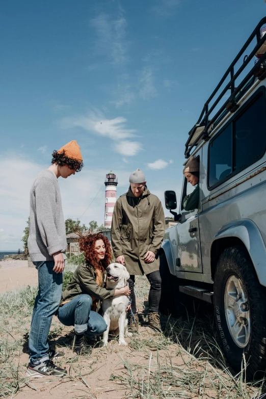 a group of people standing around a dog, land rover defender, curated collection, hemp, fishing