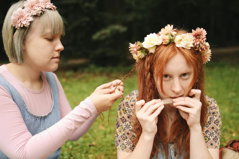 a couple of women sitting on top of a lush green field, an album cover, inspired by Elsa Beskow, pexels contest winner, renaissance, copper spiral hair decorations, wearing a floral crown, close-up photograph, ready to model