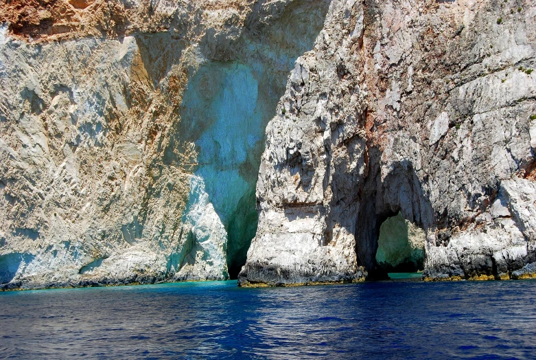 a cave in the middle of a body of water, greek nose, contrasting colours, thumbnail, wall of water either side