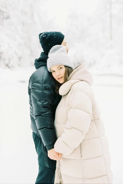 a man and woman standing next to each other in the snow, trending on unsplash, model wears a puffer jacket, high key, very comfy], russia