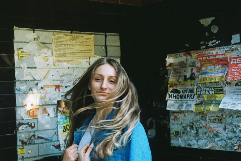 a woman with her hair blowing in the wind, an album cover, inspired by Elsa Bleda, pexels contest winner, happening, stood outside a corner shop, beautiful taissa farmiga, color film photography 1970s, shot on superia 400 filmstock