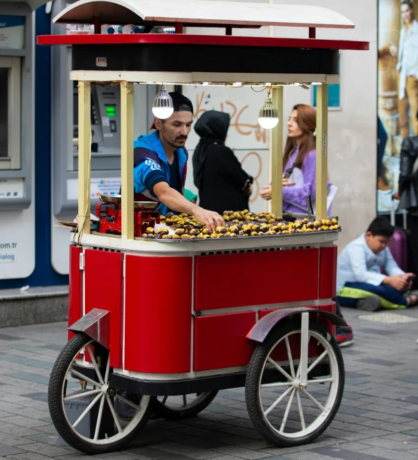 a man selling food from a cart on the street, by Julia Pishtar, pexels contest winner, pop art, ottoman sultan, nugget, cherry, coventry city centre