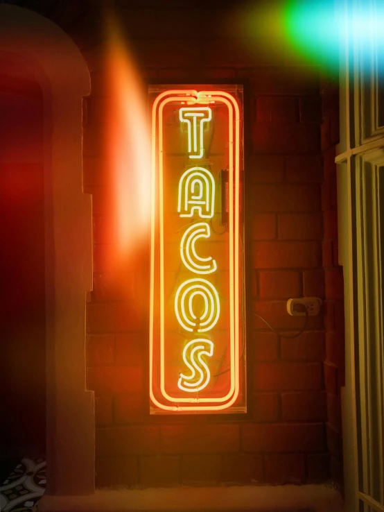 a neon sign hanging from the side of a building, tacos, profile image, running lights, a close up shot