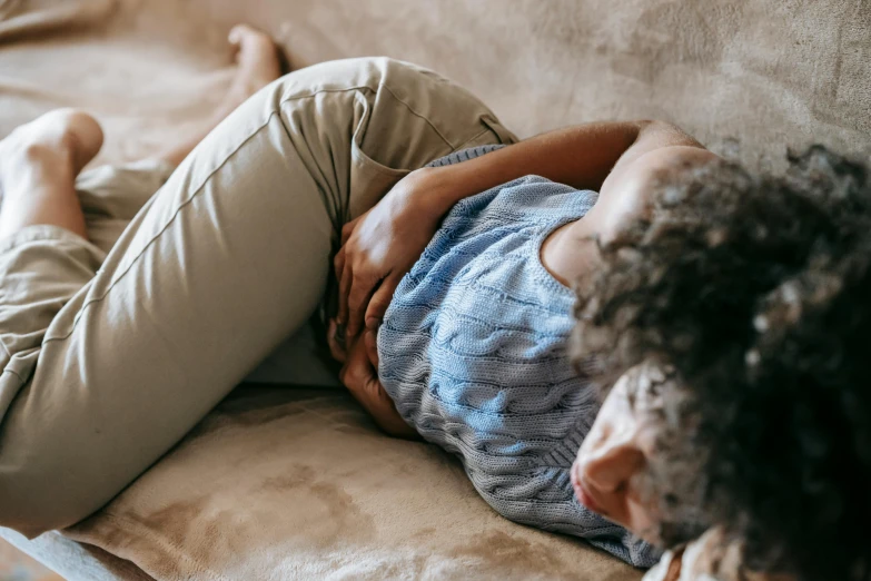 a woman laying on top of a couch next to a laptop, trending on pexels, happening, cysts, inside a cavernous stomach, gif, maternal