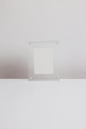 a picture frame sitting on top of a table, by Harvey Quaytman, visual art, translucent white skin, 2010s, rectangle, clear silhouette