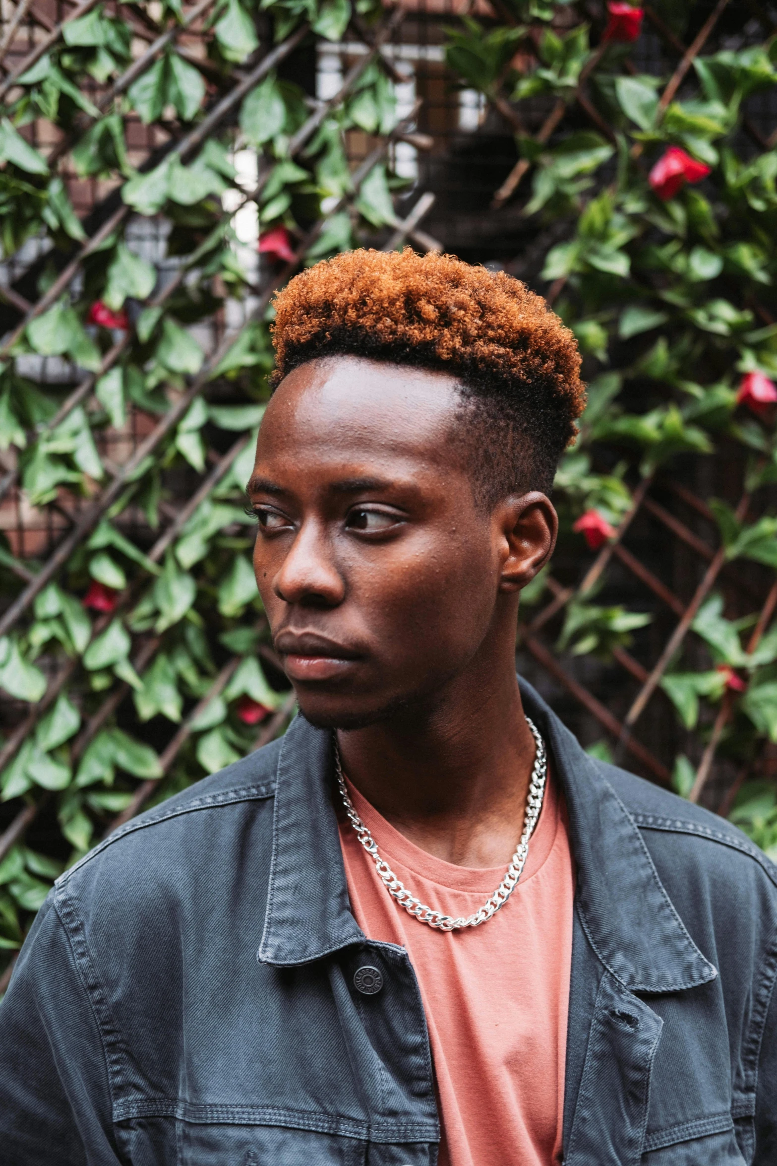 a young man standing in front of a fence, an album cover, inspired by Barthélemy Menn, trending on pexels, short copper hair, adut akech, headshot profile picture, clean shaven